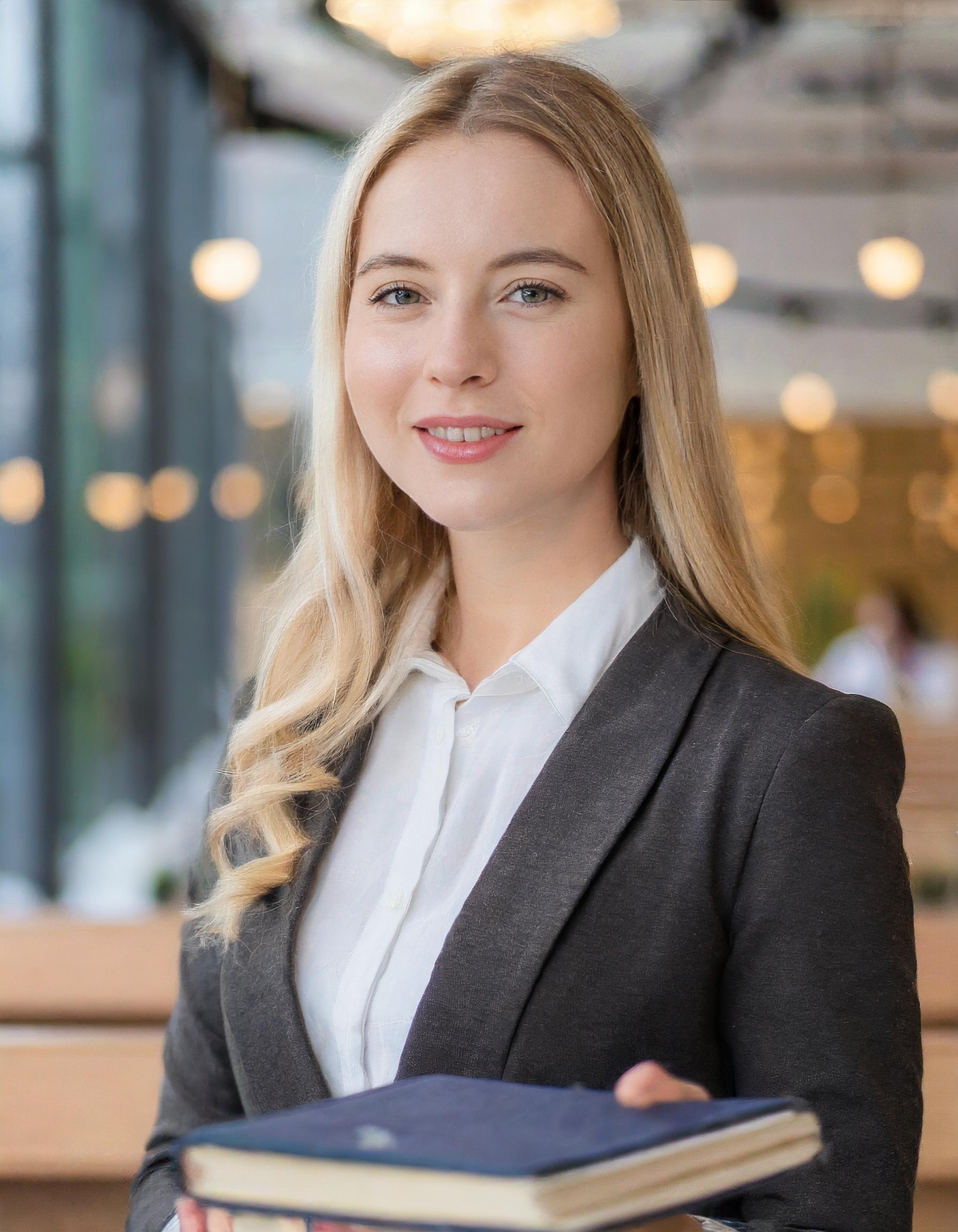 Porträt einer Frau mit freundlichem Lächeln in beruflichem Umfeld